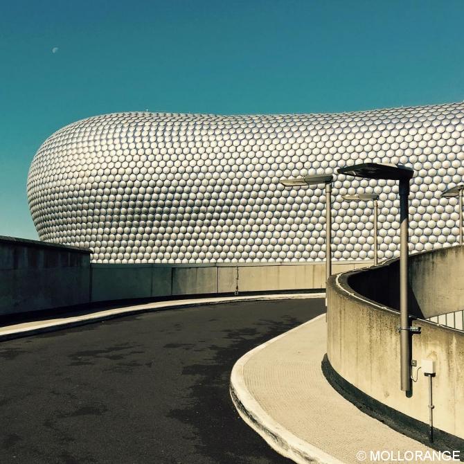 curves. car park view to the facade of the bullring shopping center. with moon.